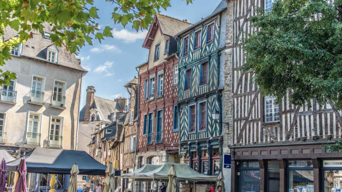 Immeuble historique à colombages avec façades traditionnelles dans une rue commerçante animée