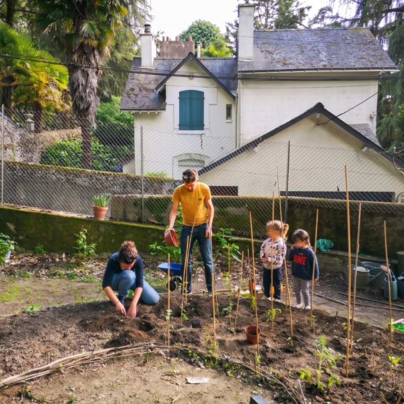 famille jardinant dans le potager d une maison avec jardin gestion nantes potagers famille 1x1