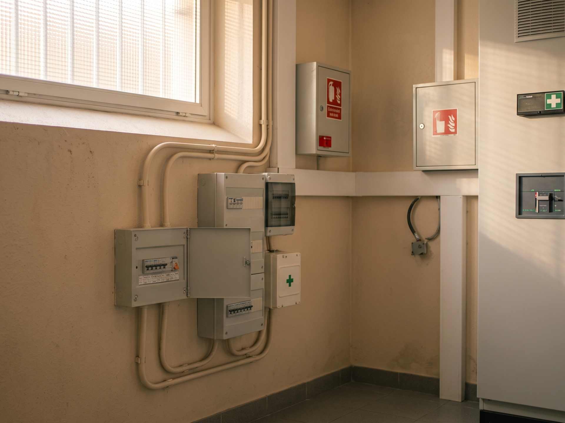 Local technique équipé d'un tableau électrique mural et de boîtiers de sécurité incendie et premiers secours